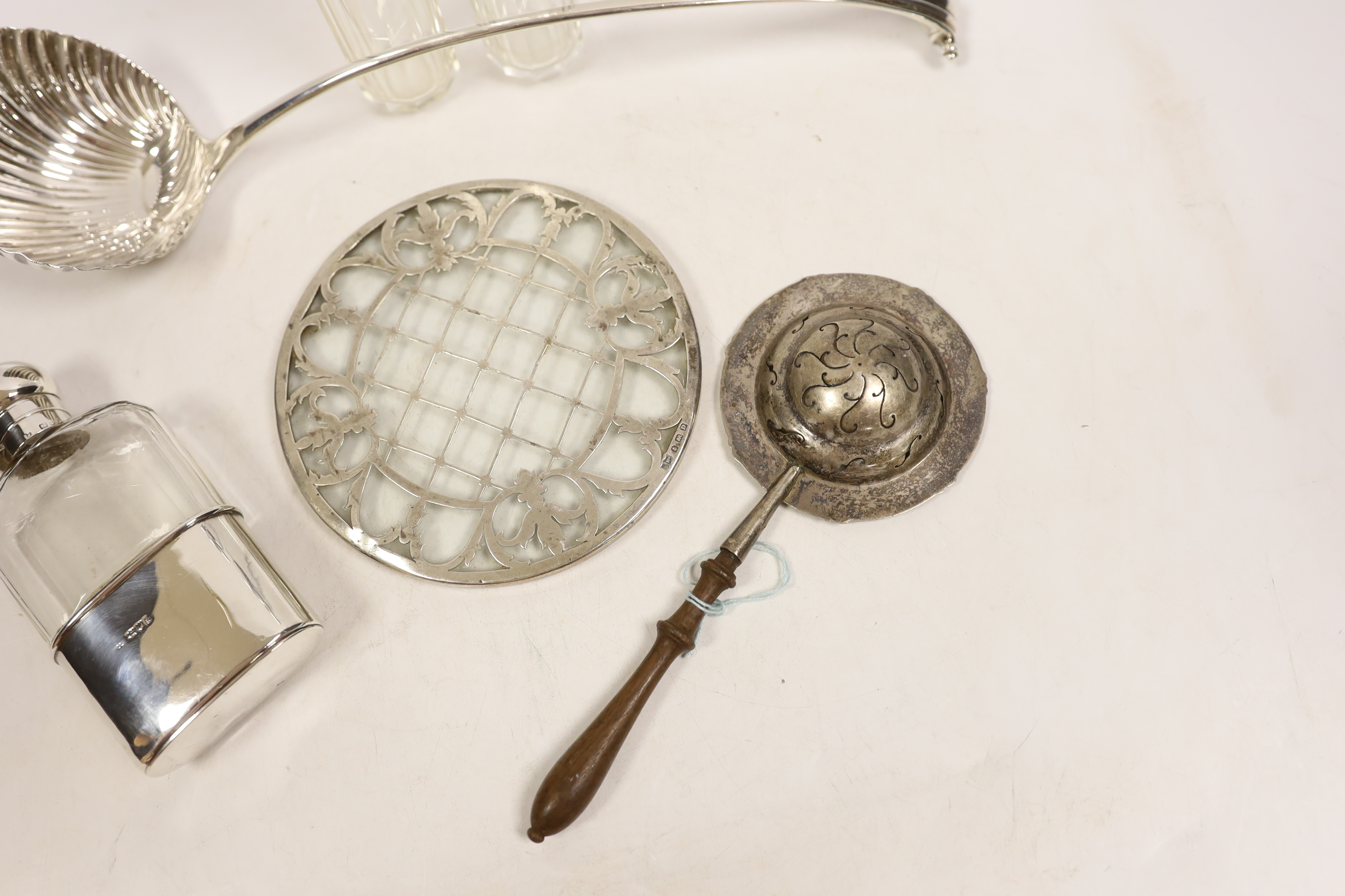 An 18th century silver base mark Onslow pattern soup ladle, indistinct marks and five other items including a silver mounted glass hip flask and a silver tea strainer with wooden handle.